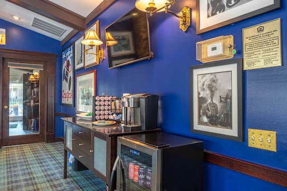 A blue wall with a framed picture and a sign on it.