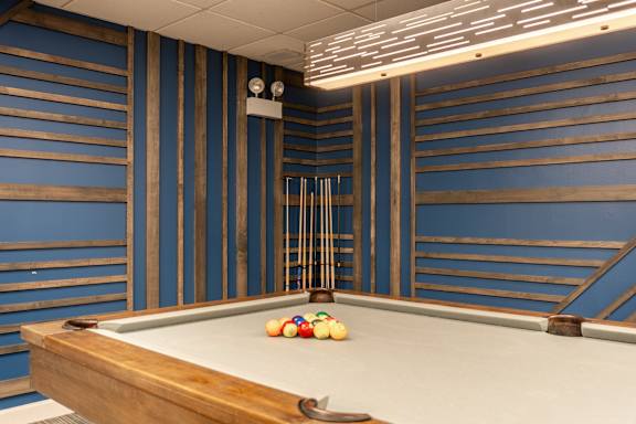 A pool table with a cue stick and balls on it.