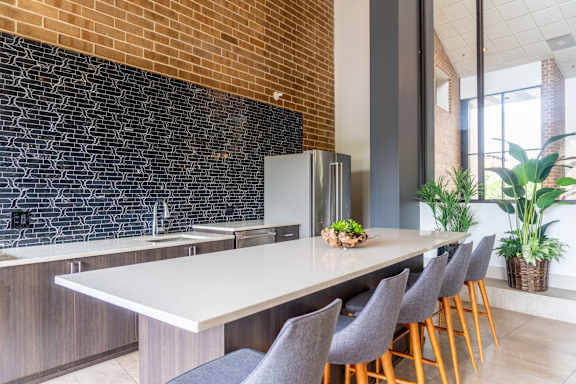 A kitchen with a long table and chairs.
