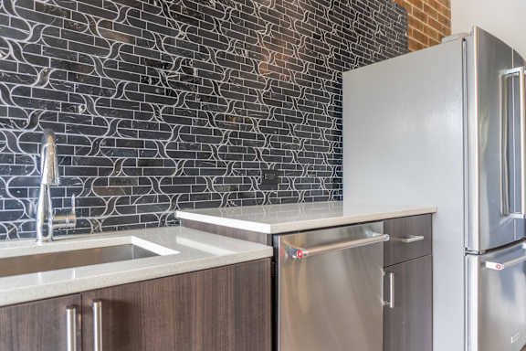 A kitchen with a stainless steel refrigerator and a sink.