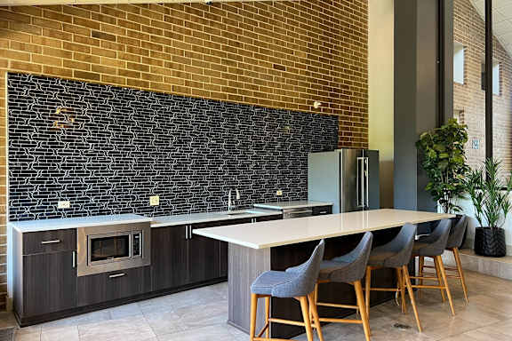 A kitchen with a long table and chairs.