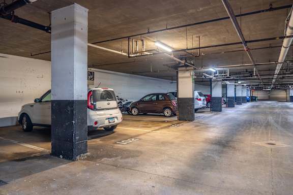 A parking garage with two cars parked.