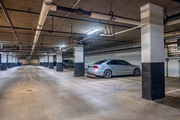 A car is parked in a large, empty parking garage.