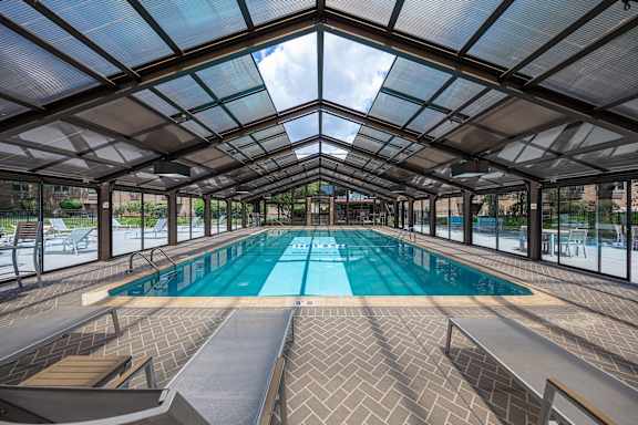 A large indoor swimming pool with a glass ceiling.