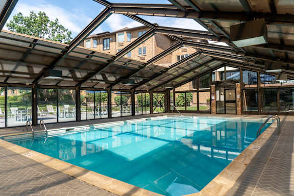 A large indoor swimming pool with a glass ceiling.