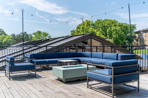 A wooden deck with blue couches and a table.