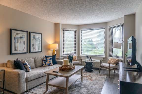 A living room with a couch, a coffee table, and a television.
