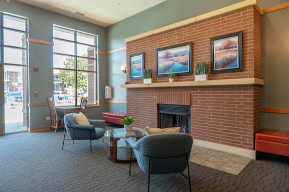 A living room with a fireplace and two chairs.