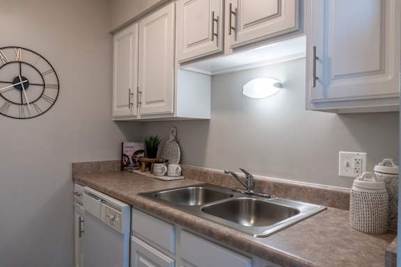 A kitchen with a clock on the wall.