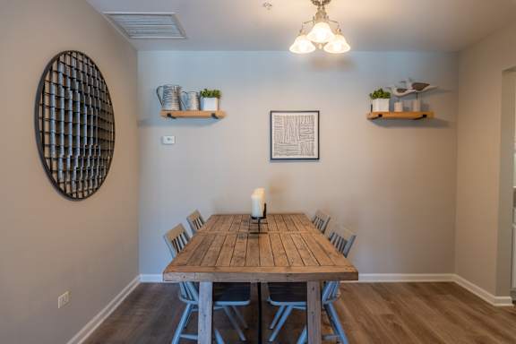 A dining room with a wooden table and chairs.