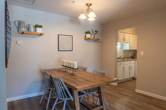 A dining room with a wooden table and chairs.