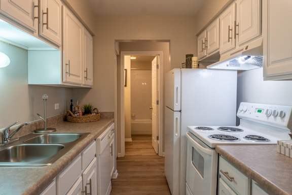 A kitchen with white appliances and cabinets.