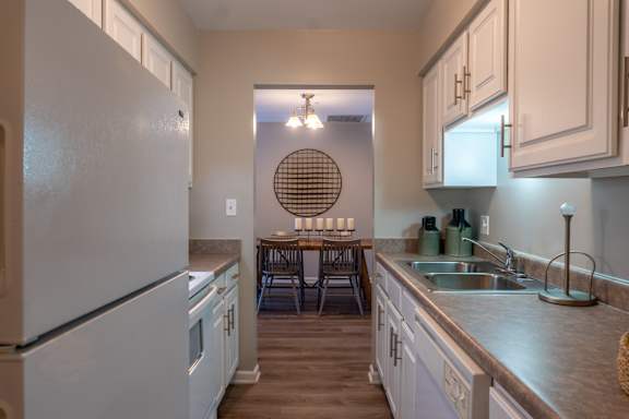 A kitchen with a white refrigerator and a round window.