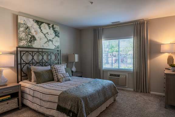 A bedroom with a large bed and a painting on the wall.