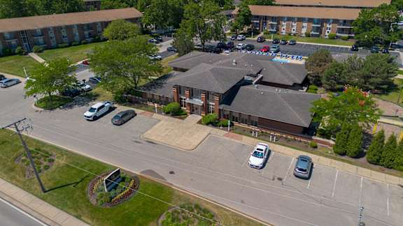 A parking lot with cars and a building in the background.
