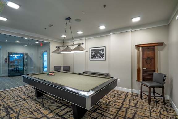 A pool table is in the middle of the room.