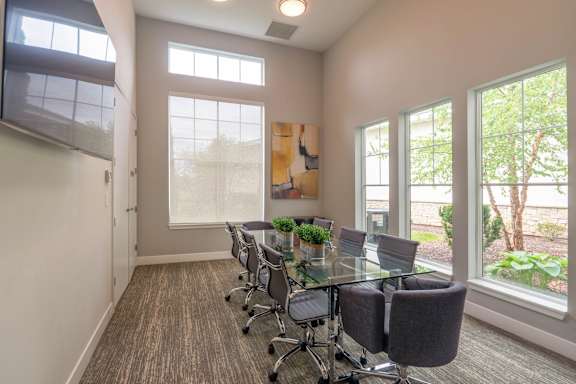 A conference room with a glass table and chairs.