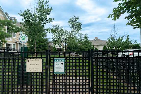 A sign on a fence warns of "Doggie Park" and "Prairie Winds.".