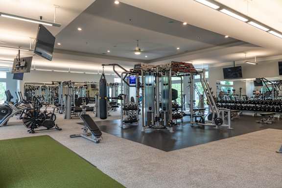 A gym with a variety of equipment including treadmills, weights, and exercise machines.