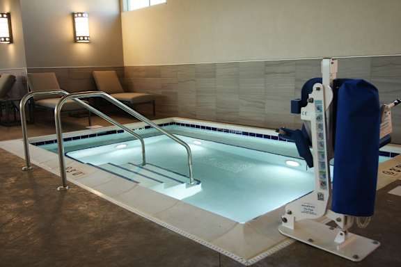 A pool with a blue cover and a ladder.