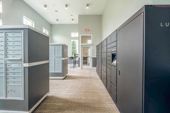 A hallway with a series of lockers on the right and a door at the end.