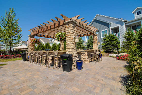 A patio with a table and chairs under a pergola.