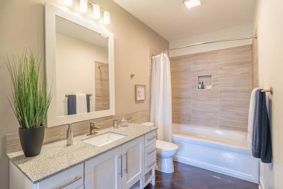 A bathroom with a white sink and a large mirror.