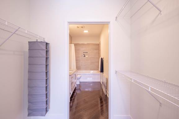A long hallway with a white wall and a white door.