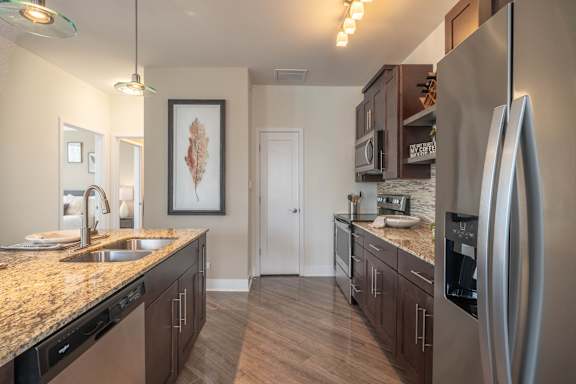 A kitchen with a granite countertop and stainless steel appliances.