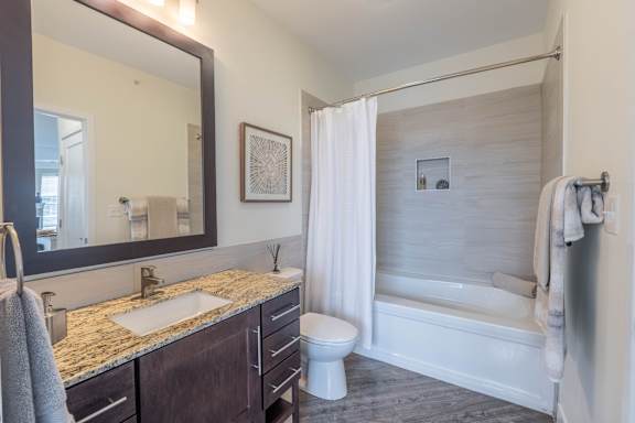 A bathroom with a sink, toilet, and bathtub.