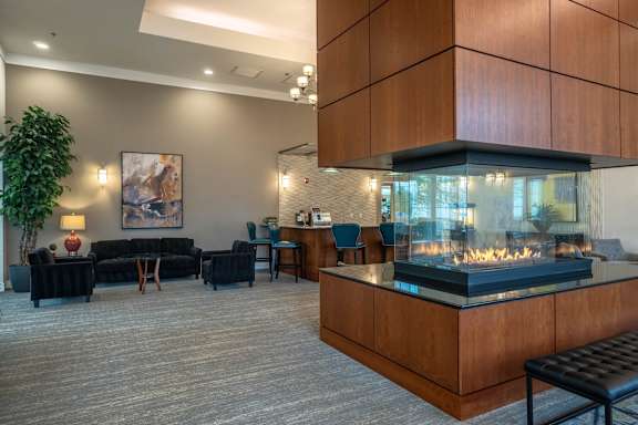 A modern living room with a fireplace and a painting on the wall.