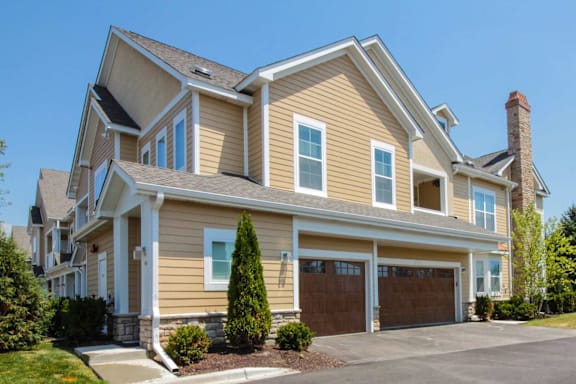 A large, two-story house with a garage and a driveway.