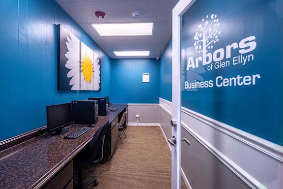 A room with computers and a sign that says Arbors Glen Ellyn Business Center.