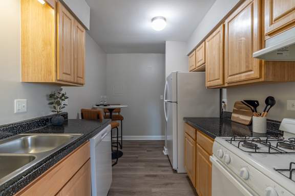 A kitchen with wooden cabinets and a white refrigerator.