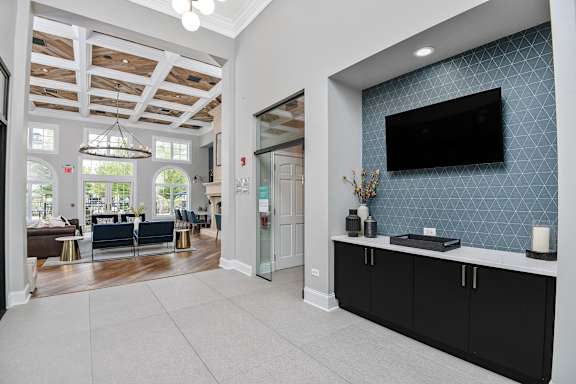 A spacious living room with a television on the wall.