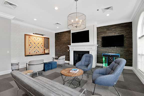 A living room with a grey couch, a coffee table, and a fireplace.