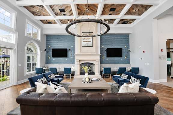 A large brown leather sofa sits in the middle of a spacious living room.
