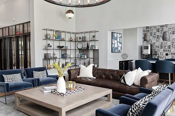 A living room with a dark blue sofa, a brown leather couch, and a wooden coffee table.