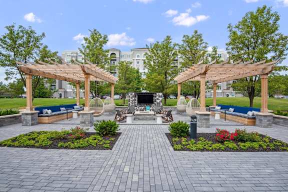 A park with a pavement and two wooden pergolas.