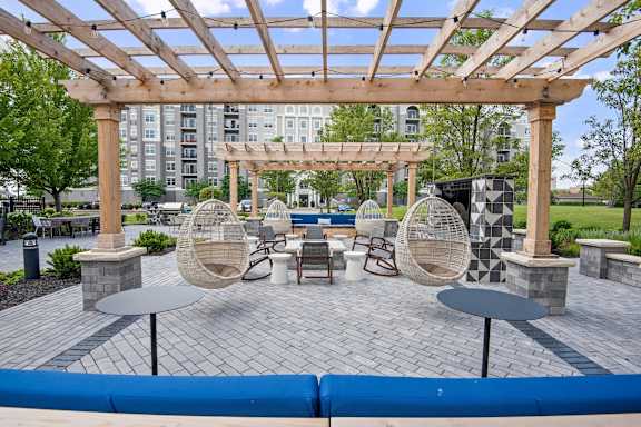 A wooden pergola with a table and chairs underneath it.
