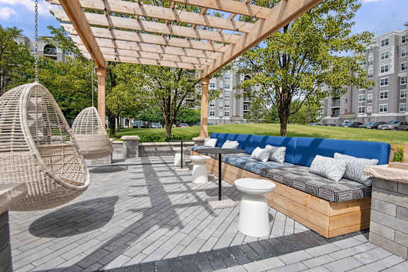 A patio with a blue couch and a white toilet.