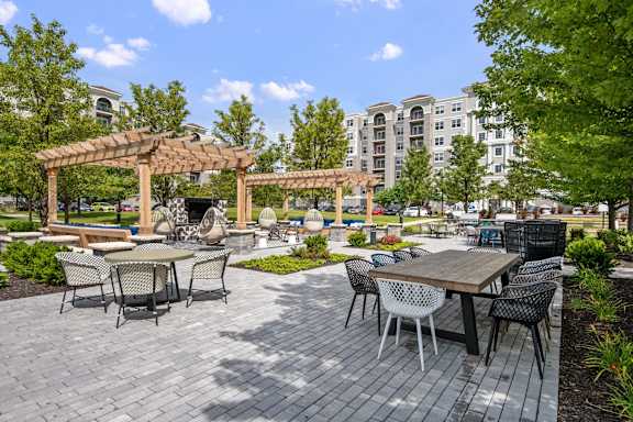 A patio with a table and chairs under a pergola.