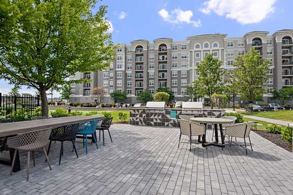 A patio with a table and chairs in front of a building.