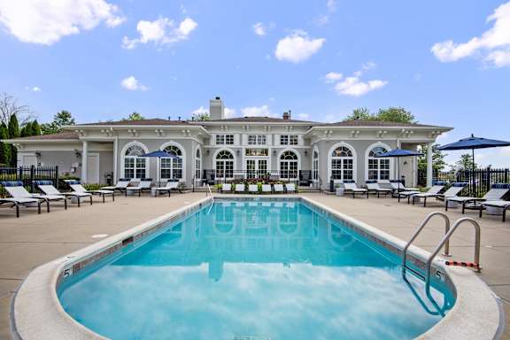A large white building with a pool in front.