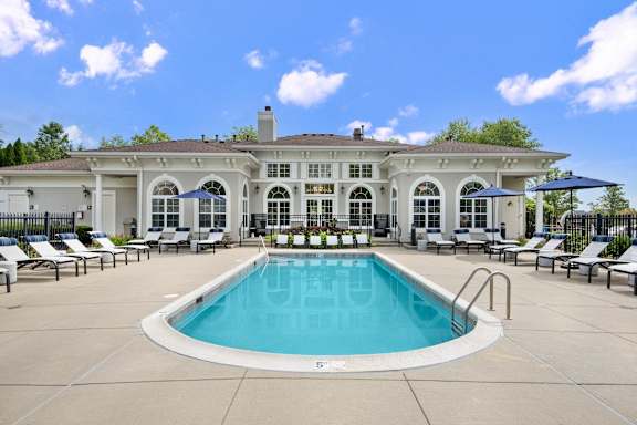A large house with a pool in front.