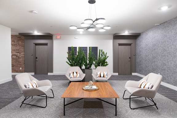 A modern living room with a wooden coffee table and grey chairs.