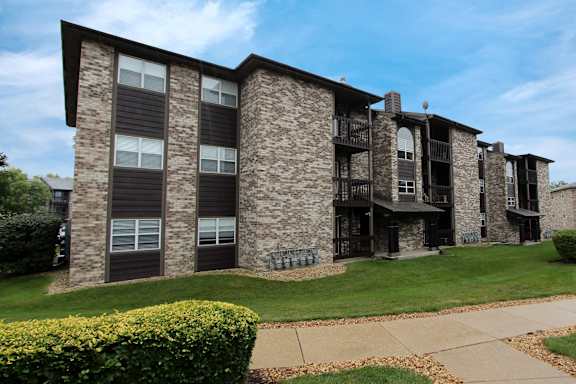 A large stone building with a balcony and a patio area.