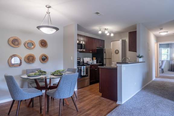 A kitchen with a dining table and chairs.