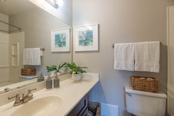 A bathroom with a white sink and a white toilet.