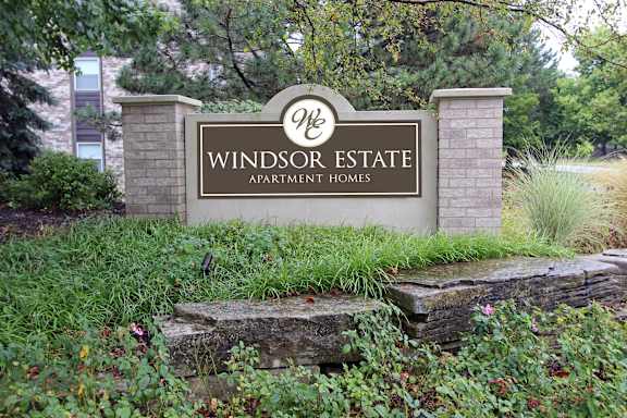 A sign for Windsor Estate Apartment Homes is in front of a building.